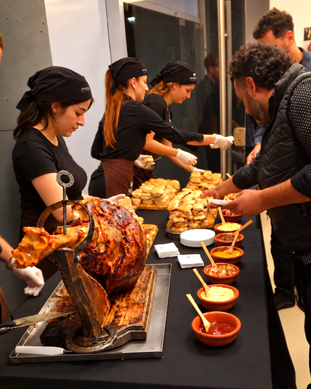 mesa de pernil de ternera con panes y salsas caseras